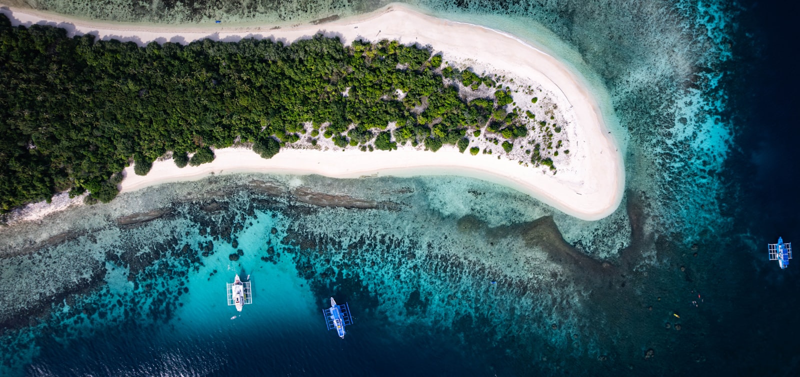 Aerial view of a tropical island with clear blue water.